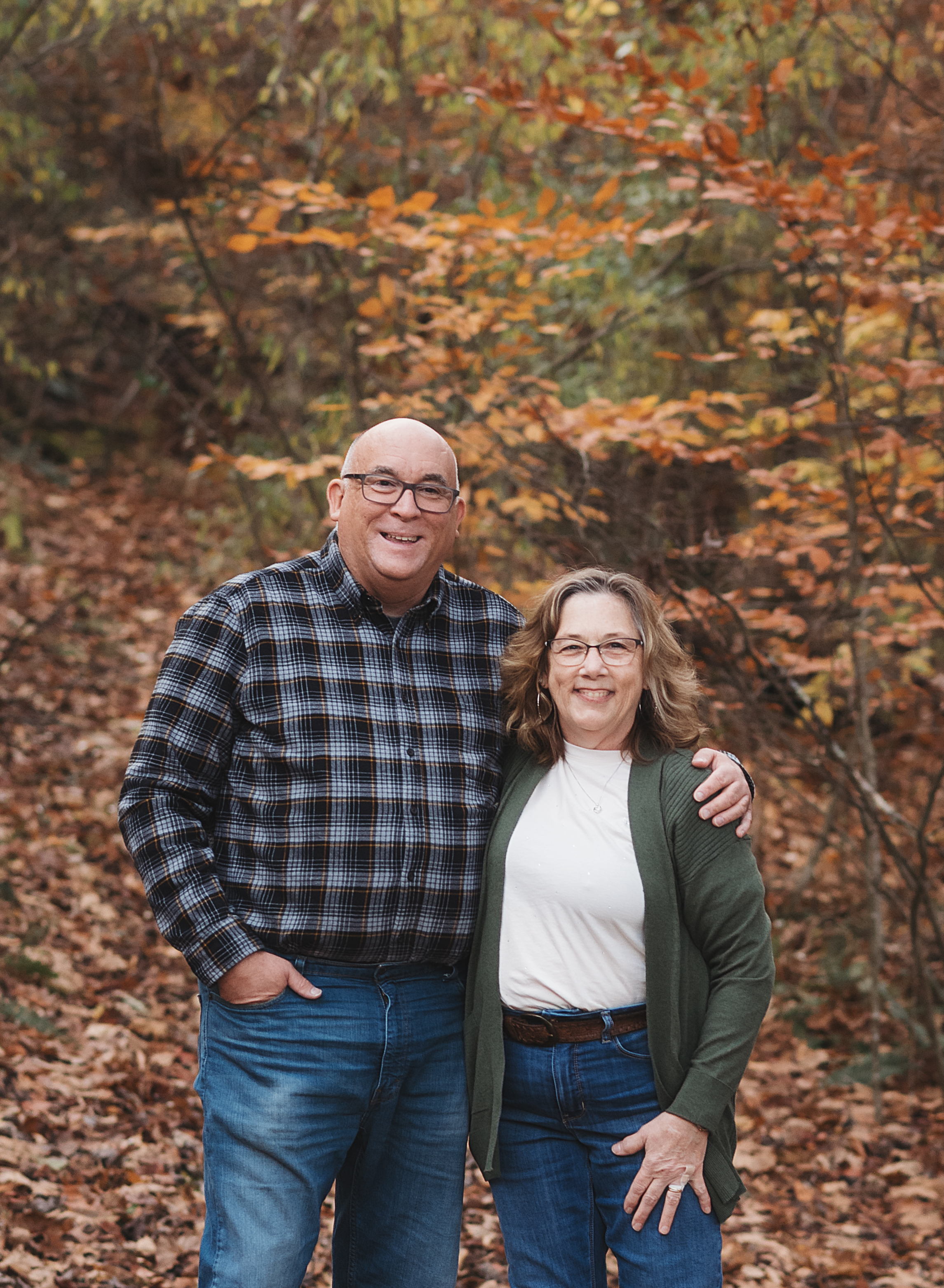 Jim Flesher pictured outdoors with a woman among autumn leaves